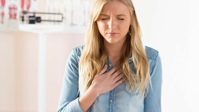 A Woman Wearing a Blue Denim Shirt, Experiencing a Heart Burn 