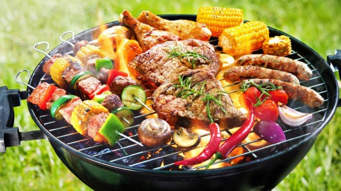 Griiled Sausage , Corn ,Chicken ,Beef ,Red Onion , Pepper ,Mushrooms ,Green Pepper and Cucumbers on Top of a Braai Stand 