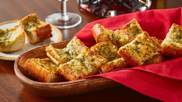 Garlic Bread in a Wood Serving Bowl Slightly Covered with a Red Cloth